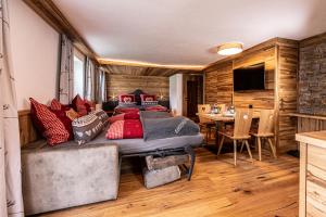 Schlafzimmer mit einem Bett mit roten Kissen und einem Tisch in der Unterkunft Gästehaus Bodnerlehen in Schönau am Königssee