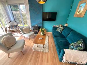 a living room with a green couch and a table at Vakantiebungalow Vrijzicht in Kortgene