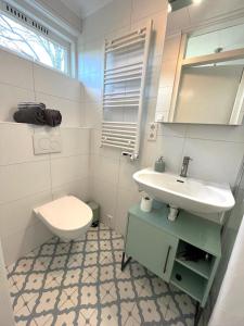 Baño blanco con lavabo y aseo en Vakantiebungalow Vrijzicht en Kortgene