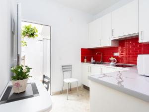 eine Küche mit weißen Arbeitsflächen und einer roten Backsteinwand in der Unterkunft EK Los Eucaliptos Fasnia in Fasnia