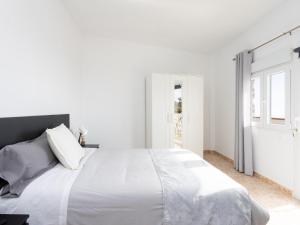 a white bedroom with a large bed and a window at EK Los Eucaliptos Fasnia in Fasnia