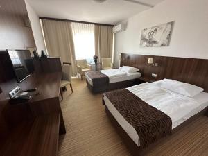 a hotel room with two beds and a television at Hotel Bratislava in Bratislava