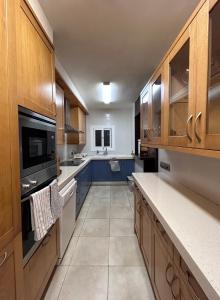 een grote keuken met houten kasten en blauwe werkbladen bij Casa Magnolia in Dosríus