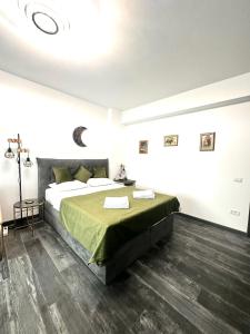 a bedroom with a large bed with a green blanket at Q Green and Comfy place near Palas in Iaşi