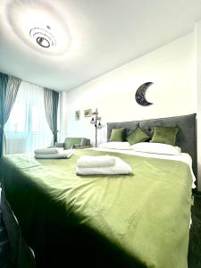 a bedroom with a large green bed with pillows on it at Q Green and Comfy place near Palas in Iaşi