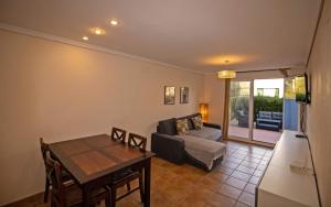 salon z kanapą i stołem w obiekcie Planta baja con terraza chill out - Primera línea Tres Playas - ALBERT VILLAS w mieście Alcossebre