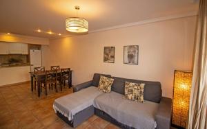 salon z kanapą i stołem w obiekcie Planta baja con terraza chill out - Primera línea Tres Playas - ALBERT VILLAS w mieście Alcossebre