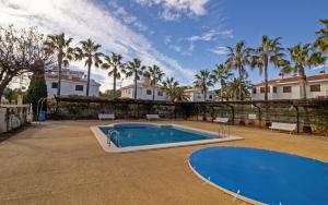 a swimming pool in a yard with palm trees at Planta baja con terraza chill out - Primera línea Tres Playas - ALBERT VILLAS in Alcossebre