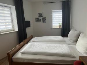 two beds in a room with two windows at Bierstadt-Hotel in Einbeck