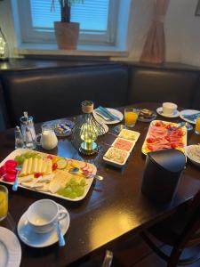 a table with plates of food on top of it at Bierstadt-Hotel in Einbeck