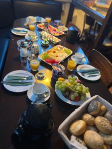 a table topped with plates of food and fruit at Bierstadt-Hotel in Einbeck