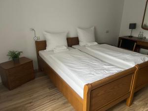 a bedroom with a large bed with white sheets at Bierstadt-Hotel in Einbeck