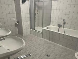 a bathroom with a tub and a sink and a shower at Bierstadt-Hotel in Einbeck