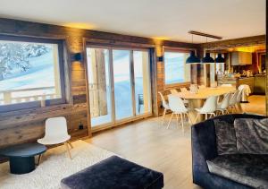 ein Wohnzimmer mit einem Tisch und einem Esszimmer in der Unterkunft Paradis Perdu SKI IN & QUIET chalet 14 personnes in Les Collons