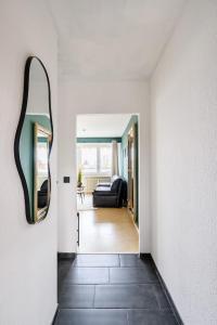 a hallway with a black couch and a mirror at Studio Apart - Küche - Balkon - Netflix in Bad Säckingen