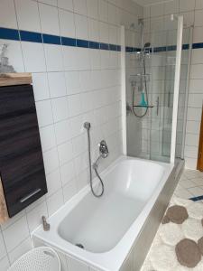 a bath tub with a shower in a bathroom at Pappert in Ebersburg