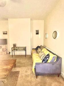 a living room with a couch and a table at Peaceful park side apartment in Hastings