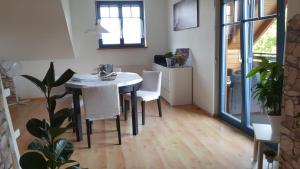 a dining room with a table and white chairs at Pappert in Ebersburg