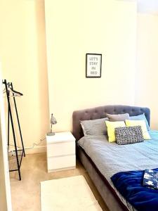 a bedroom with a bed and a night stand at Peaceful park side apartment in Hastings