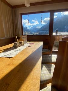 Zimmer mit einem Tisch und einem großen Fenster mit Bergblick in der Unterkunft Stadtalm Islitzer in Mittersill