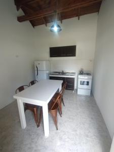 a kitchen with a white table and some chairs at Complejo 1919 in El Bolsón