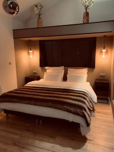 a bedroom with a large bed with a large headboard at L’Autre Nuit 