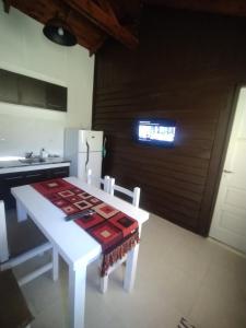 cocina con mesa blanca y nevera blanca en Complejo 1919, en El Bolsón 19 fotos más
