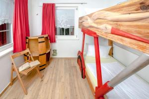 a small bedroom with a bunk bed and a chair at Ferienwohnung Storchennest in Neuendorf am See