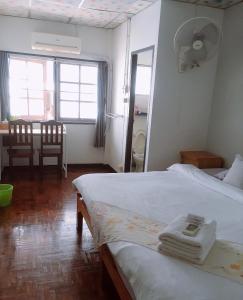 a bedroom with two beds and a dining room with a table at Wayside Guesthouse in Chiang Mai