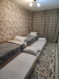 two twin beds in a bedroom with wallpaper at Квартира LUX, Lux apartment in Taraz