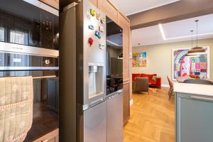 a kitchen and a living room with a refrigerator at Casa Alexandra - Luxury & Design in Castellammare del Golfo