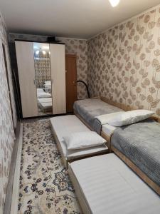 a room with three beds and a mirror at Квартира LUX, Lux apartment in Taraz