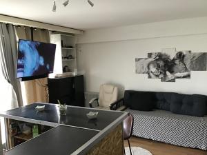 a living room with a black couch and a flat screen tv at FLAT Calais beach in Calais