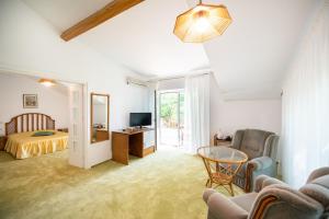 ein Wohnzimmer mit einem Bett und ein Zimmer mit einem Tisch in der Unterkunft Vila Elena in Eforie Nord