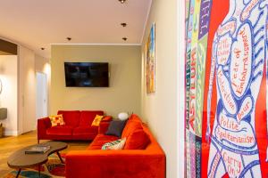 a living room with a red couch and a table at Casa Alexandra - Luxury & Design in Castellammare del Golfo