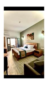 a bedroom with a large bed and a couch at Royal Goddess Guest House, Walled City in Famagusta