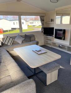 a living room with a couch and a table at Family Caravan, Seton sands, Haven holiday village in Port Seton