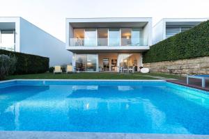 a swimming pool in front of a house at Akivillas Sintra Star in Sintra