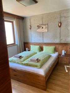 ein Schlafzimmer mit einem großen Holzbett mit grüner Bettwäsche in der Unterkunft Stadtalm Islitzer in Mittersill