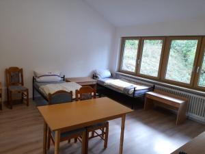 een kamer met 2 bedden, een tafel en ramen bij Schöne Monteurunterkunft in Lohberg mit Grillplatz und Balkon in Lohberg