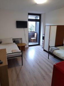 een kamer met 2 bedden, een televisie en een stoel bij Schöne Monteurunterkunft in Lohberg mit Grillplatz und Balkon in Lohberg