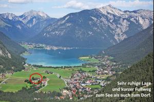 a view of a village with a lake and mountains at Appartements Achensee in Maurach