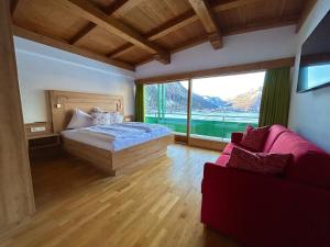 a bedroom with a bed and a large window at Appartements Achensee in Maurach