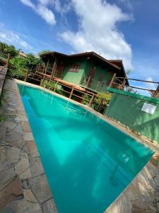 a villa with a swimming pool in front of a house at Brisa Maresias in Maresias