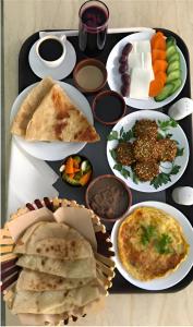 Sama Sohar Hotel Apartments - سما صحار للشقق الفندقية في صحار: صينية مليئة بأنواع مختلفة من الطعام على طاولة