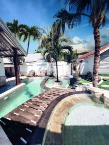una piscina con palmeras junto a una casa en The White Key Luxury Villas, en Gili Trawangan