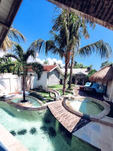 a swimming pool in a backyard with palm trees at The White Key Luxury Villas in Gili Trawangan