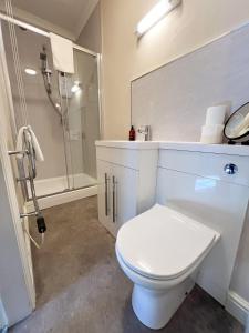 a white bathroom with a toilet and a shower at The Exchange Hotel in Brigg