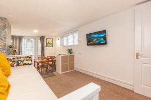 a living room with a couch and a dining room at The Corner Stop~ Dog Friendly Holiday Let in Plymouth in Plymouth