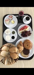 ein Tablett mit Teller mit Lebensmitteln auf einem Tisch in der Unterkunft Sama Sohar Hotel Apartments - سما صحار للشقق الفندقية in Suhar